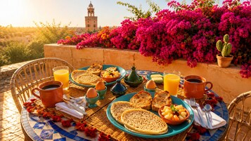 Una mesa servida con alimentos para el desayuno, incluyendo pan, huevos y fruta, con una torre al fondo.