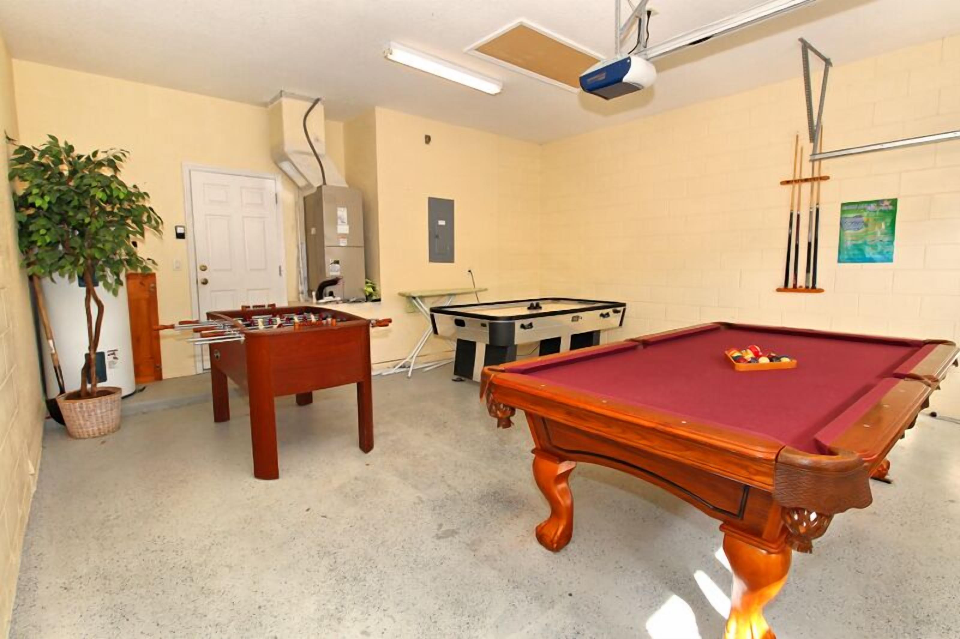 Une salle de loisirs équipée d’une table de billard, d’un baby-foot et d’une table de jeu de fléchettes.