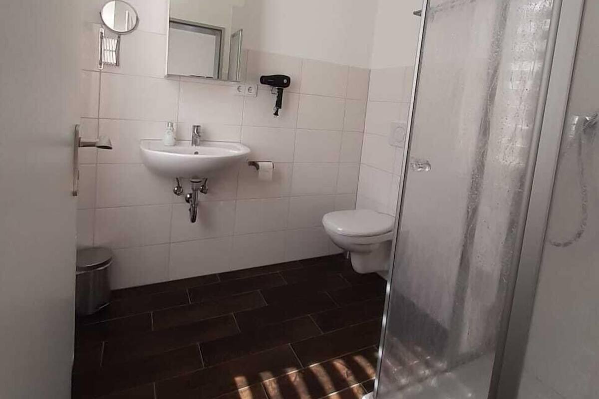 Un baño con ducha, lavamanos e inodoro.