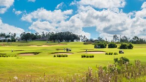 A golf course with bunkers, fairways, and a clubhouse in the background. - Ov3125 - Highlands Reserve - 6 Bed 4 Baths Villa (Davenport)