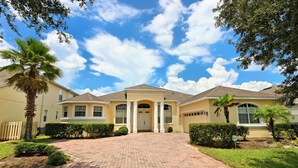 A two-story house with a central entrance, a covered porch, and a paved driveway.