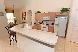 Enjoy cooking in this well-equipped kitchen with a central island, microwave, oven, and refrigerator.