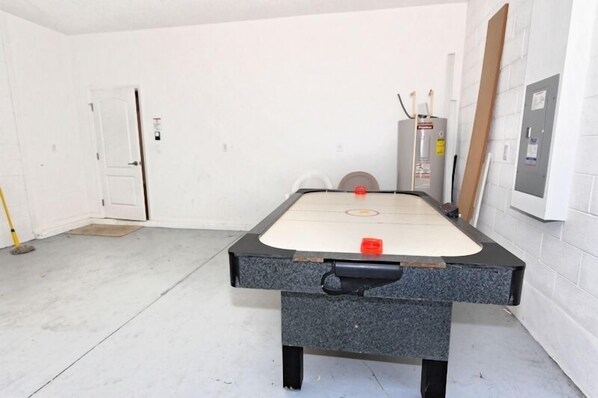 A room with a foosball table, a door, and a utility meter on the wall. - Ov3113 - The Shire at West Haven - 5 Bed 4 Baths Villa (Davenport)