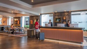Egy modern stílusú, tágas hotelrecepció, melyben található egy recepciós pult, egy ülősarok és nagy ablakok, melyek kilátást nyújtanak.