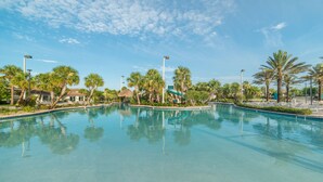 A clear swimming pool surrounded by palm trees and lounge chairs, with a clear sky above. - Ov3105 - Champions Gate Resort - 6 Bed 6 Baths Villa (Davenport)