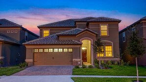 Une maison d’habitation avec un garage, une allée et une pelouse bien entretenue.
