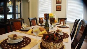 A dining table set with a cake, wine glasses, and plates of food. - Ov3057 - Reunion Resort - 4 Bed 3.5 Baths Villa (Kissimmee)