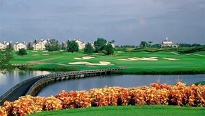 A golf course with a water body, a bridge, and a clubhouse in the background. - Ov3057 - Reunion Resort - 4 Bed 3.5 Baths Villa (Kissimmee)