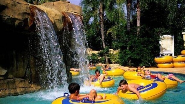 A water park with people floating on yellow tubes and a waterfall. - Ov3057 - Reunion Resort - 4 Bed 3.5 Baths Villa (Kissimmee)