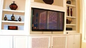 A living room with a large flat-screen TV mounted on a white entertainment unit. - Ov3057 - Reunion Resort - 4 Bed 3.5 Baths Villa (Kissimmee)