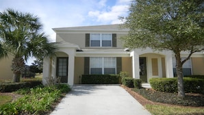 A two-story house with a front entrance, a covered porch, and a driveway leading to the front door. - Ov3007 - Windsor Hills Resort - 3 Bed 3 Baths Townhome (Kissimmee)