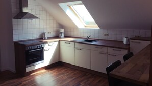 Een compacte keuken met dakraam, koffiezetapparaat en broodrooster.