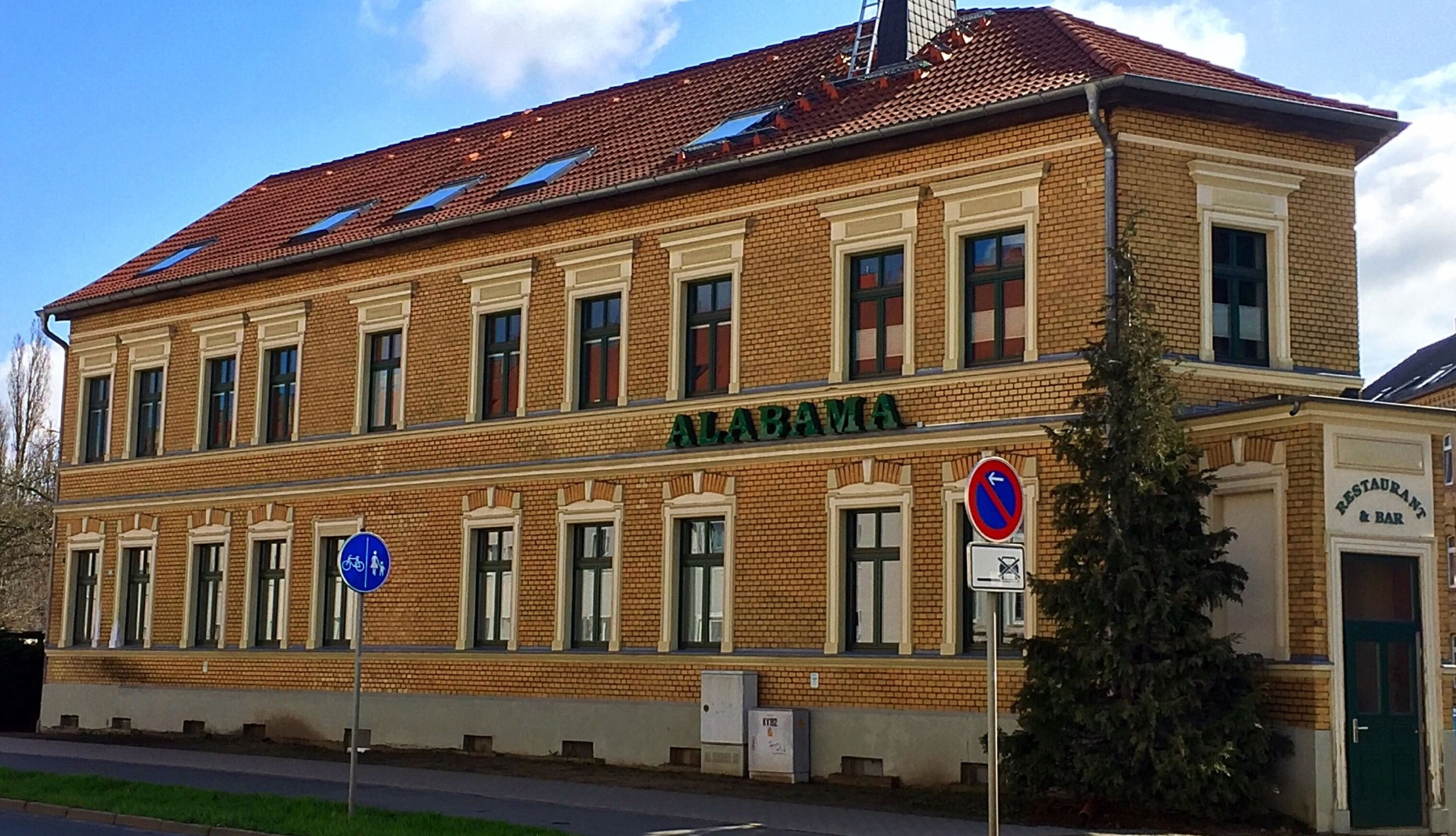 Ein zweistöckiges Gebäude mit einem Schild, auf dem "ALABAMA" steht.