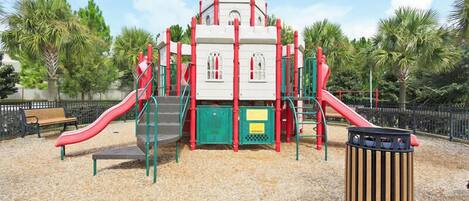 A playground with a slide, climbing structures, and a bench.
