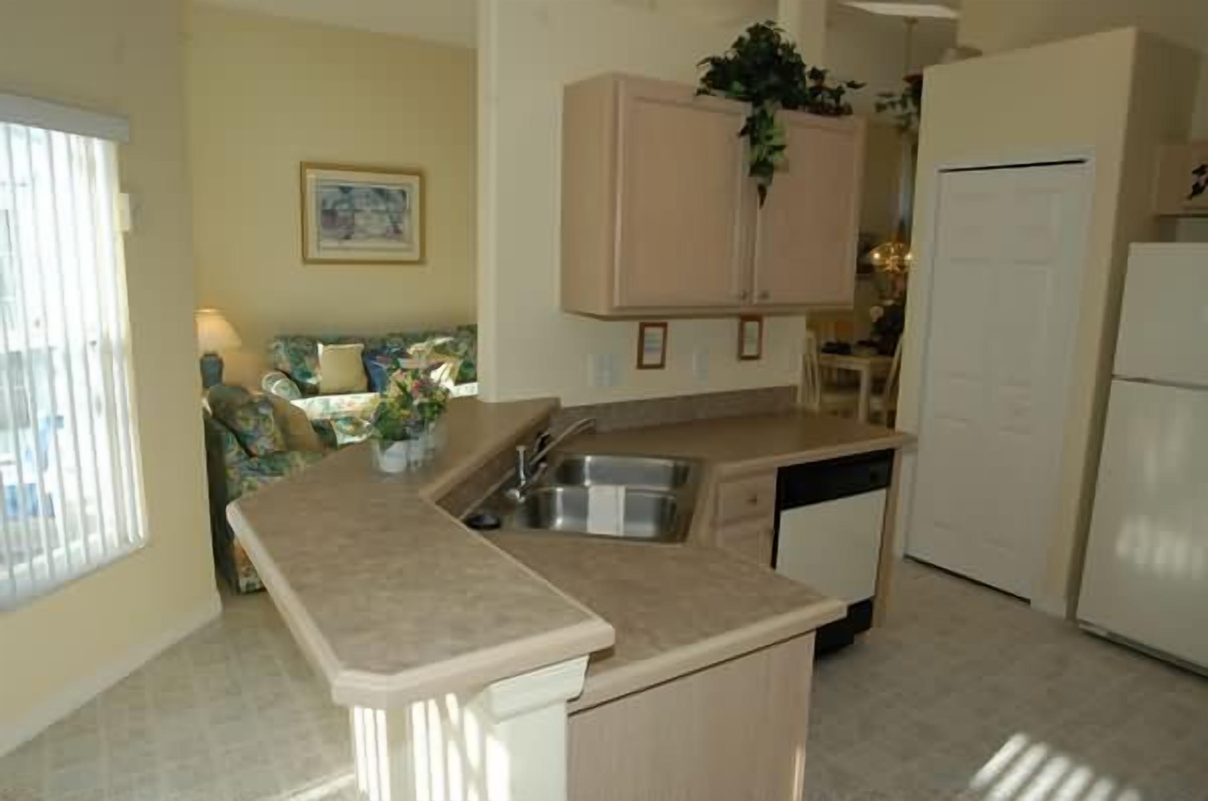 A compact kitchen with a built-in sink, a small island, and a refrigerator.
