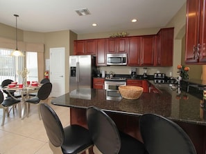 Enjoy cooking in this well-equipped kitchen with a central island, stainless steel appliances, and ample dining space.