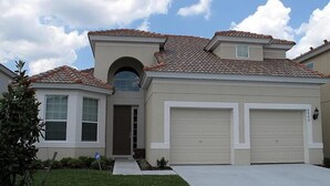 A two-story house with a garage, a covered front porch, and a small front yard.