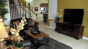 A living room with a sofa, coffee table, and TV stand.