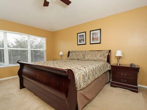 A bedroom with a large bed, two bedside tables, a window with blinds, and two framed pictures on the wall. - Ov2921 - Windsor Hills Resort - 6 Bed 4 Baths Villa (Kissimmee)