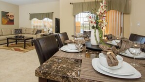 A dining area with a marble table, leather chairs, and a vase of flowers. - Ov2899 - Paradise Palms - 4 Bed 3 Baths Townhome (Kissimmee)
