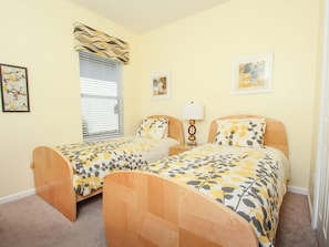 A bedroom with two wooden beds, a window with blinds, a bedside table with a lamp, and two framed pictures on the wall. - Ov2922 - Windsor Hills Resort - 4 Bed 4 Baths Townhome (Kissimmee)