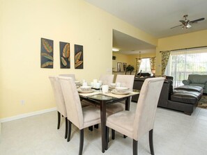 A dining area with a table set for four, surrounded by four chairs. There are three framed leaf paintings on the wall above the table. - Ov2922 - Windsor Hills Resort - 4 Bed 4 Baths Townhome (Kissimmee)