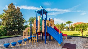 A playground with a slide, climbing structures, and a covered play area.