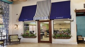 A storefront with a blue awning, a wooden door, and potted plants. - Ov2889 - Paradise Palms - 4 Bed 3 Baths Townhome (Kissimmee)