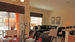 A dining area with a dark wooden table set for six, surrounded by black chairs. A vase with flowers is placed on the table. - Ov2889 - Paradise Palms - 4 Bed 3 Baths Townhome (Kissimmee)