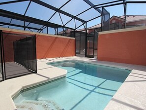 An indoor swimming pool with a glass ceiling, surrounded by walls with a geometric pattern.