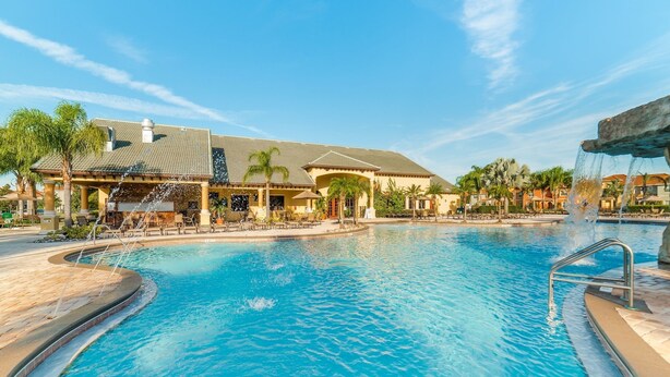 A swimming pool with a water feature, surrounded by lounge chairs and palm trees. - Ov2903 - Paradise Palms - 5 Bed 4 Baths Villa (Kissimmee)