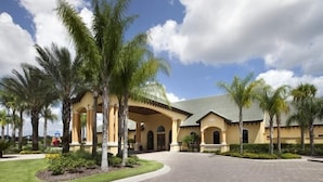 Ein Hotel mit Innenhof, Palmen und blauem Himmel.