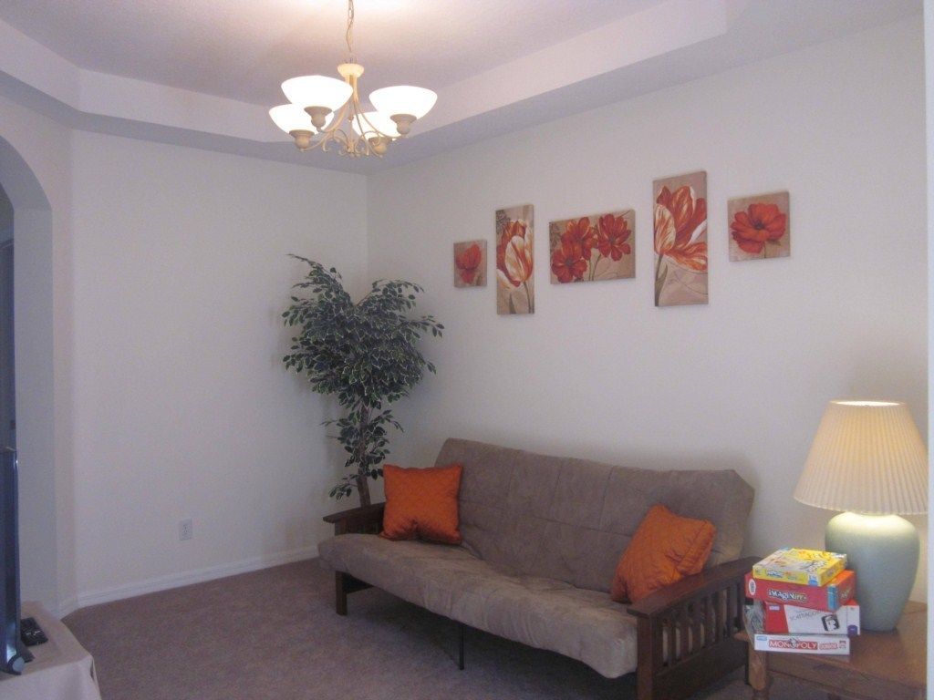 A living room with a sofa, a lamp, and a plant.