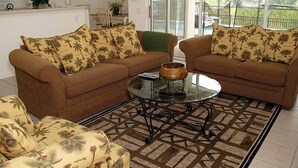 A living room with two brown sofas, a glass coffee table, and a patterned rug. - Ov2608 - Windsor Hills Resort - 5 Bed 5 Baths Villa (Kissimmee)