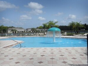 A swimming pool with a water fountain, tiled deck, and lounge chairs. - Ov2762 - Trafalgar Village Resort - 4 Bed 4 Baths Villa (Kissimmee)