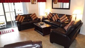 A living room with two leather sofas, a coffee table, and a bench. - Ov2644 - Emerald Island - 3 Bed 2.5 Baths Townhome (Kissimmee)