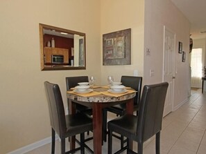 A dining area with a round table, four chairs, and a painting on the wall. - Ov2609 - Windsor Hills Resort - 3 Bed 3 Baths Townhome (Kissimmee)