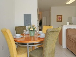 A dining area with a round table, chairs, and a vase of flowers. - Ov2563 - Windsor Hills Resort - 3 Bed 3 Baths Townhome (Kissimmee)