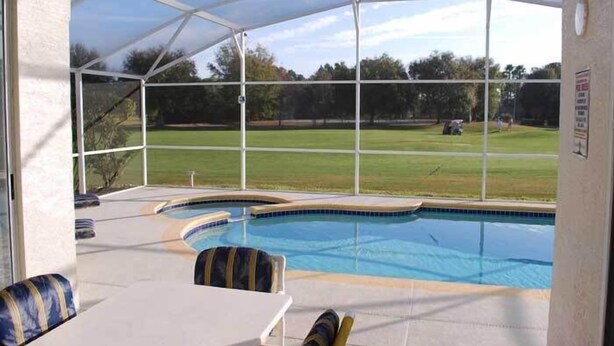 A covered outdoor swimming pool with a view of a grassy field and trees. - Ov2682 - Espirit - 4 Bed 2.5 Baths Villa (Davenport)