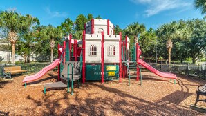 A playground with slides and climbing structures, surrounded by trees and a clear sky. - Ov2658 - Windsor Hills Resort - 5 Bed 5 Baths Villa (Kissimmee)
