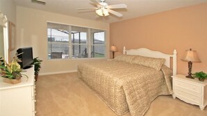 A bedroom with a bed, bedside tables, a ceiling fan, a window with blinds, and a TV on a dresser. - Ov2658 - Windsor Hills Resort - 5 Bed 5 Baths Villa (Kissimmee)