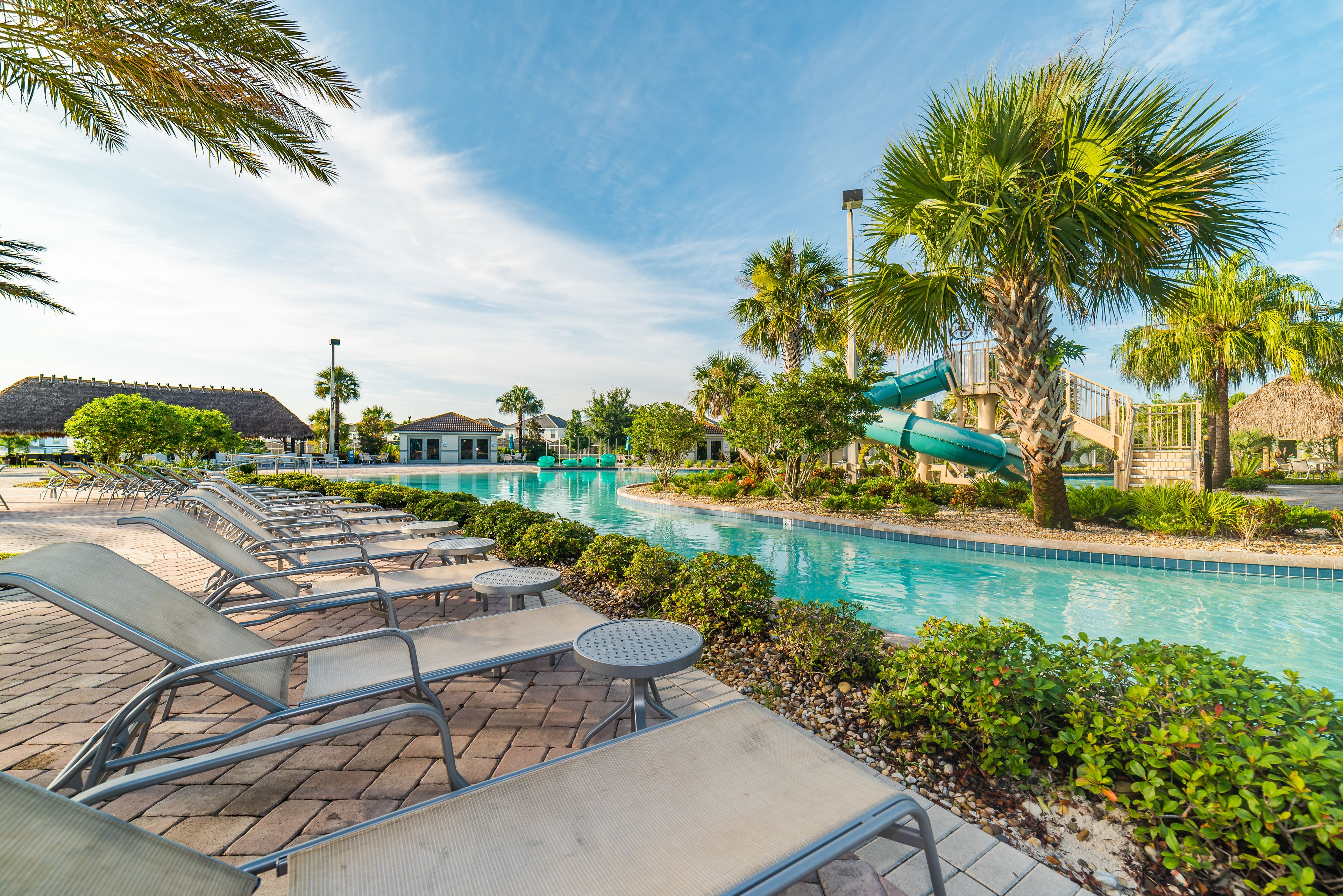 A pool area with lounge chairs and a water slide.