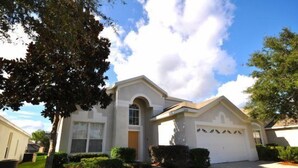 A single-story house with a garage, surrounded by well-maintained lawns and trees. - Ov2417 - Windsor Palms Resort - 6 Bed 3.5 Baths Villa (Kissimmee)