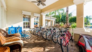 A covered outdoor area with a ceiling fan, wicker furniture, and a row of bicycles. - Ov2417 - Windsor Palms Resort - 6 Bed 3.5 Baths Villa (Kissimmee)