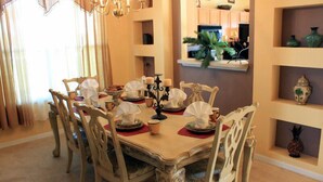 A dining area with a round table set for six, surrounded by ornate chairs. - Ov2182 - Emerald Island - 7 Bed 5.5 Baths Villa (Kissimmee)