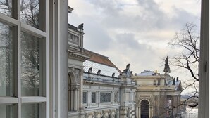 A view through a window of a historic building with ornate architecture, including statues and detailed stonework. - Hofgärtnerhaus (Dresden)