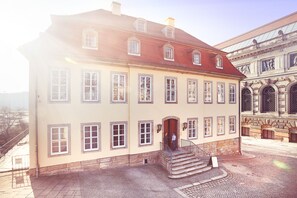 A historic building with a symmetrical facade, multiple windows, and a central entrance with steps. - Hofgärtnerhaus (Dresden)