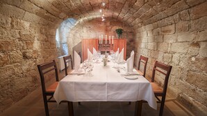 A dining table set for six in a stone-walled room with a vaulted ceiling. - Hofgärtnerhaus (Dresden)