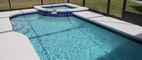 Een seizoensgebonden buitenzwembad en ligstoelen