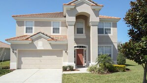 A two-story house with a garage, a front entrance with a door, and a tiled roof. - Ov2542 - Windsor Hills Resort - 6 Bed 4 Baths Villa (Kissimmee)